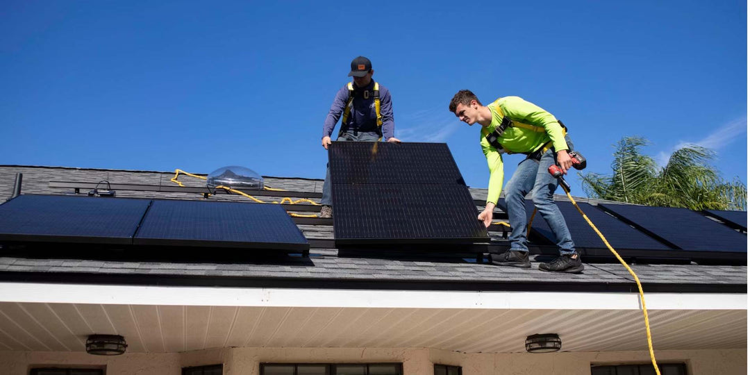 2 male workers installing solar panels for the property roof