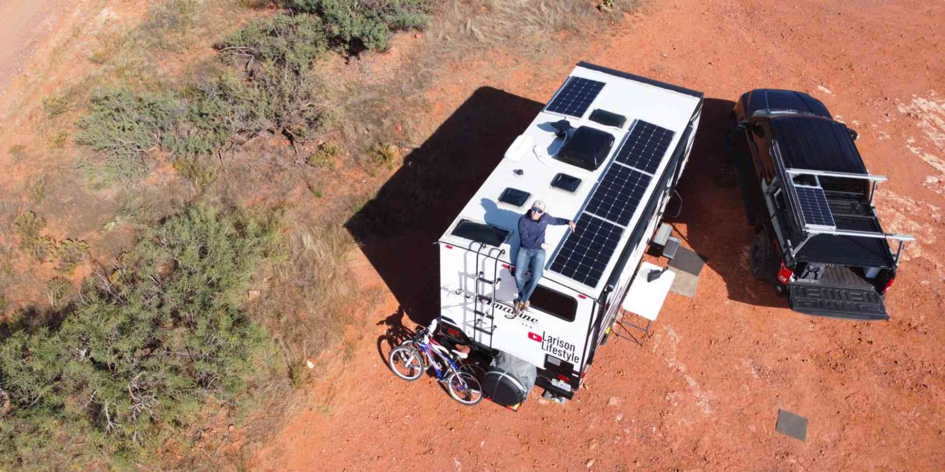 A man sitting on the RV roof with BougeRV’s rigid solar panels for camping