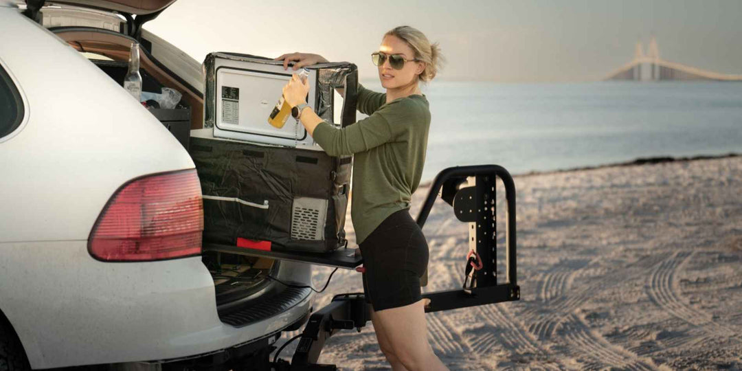 A woman grabbing a drink from a BougeRV mini fridge in her car